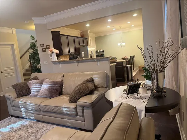 a living room with furniture and a dining table with kitchen view