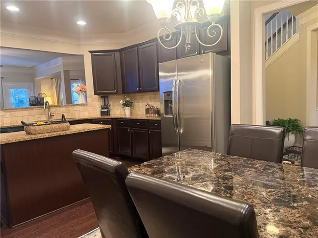 a kitchen with stainless steel appliances granite countertop a sink and a refrigerator