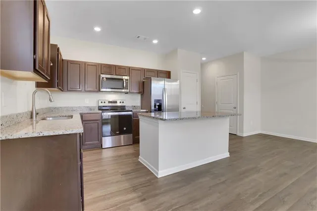a kitchen with stainless steel appliances granite countertop a sink stove and refrigerator