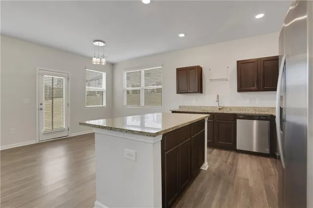 a kitchen with stainless steel appliances granite countertop a sink and a stove top oven