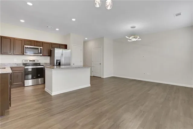 a view of kitchen with kitchen island microwave and cabinets