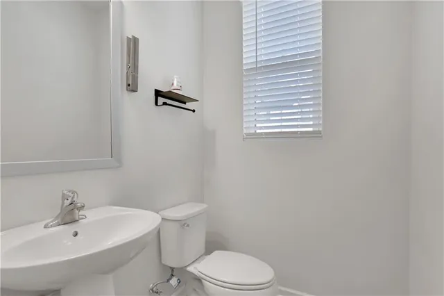 a white toilet sitting next to a white sink