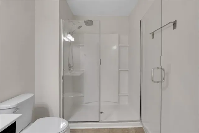 a bathroom with a shower a toilet and sink