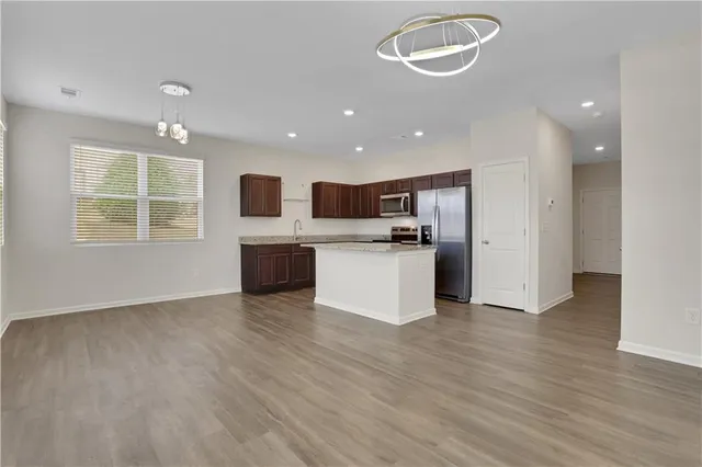 a view of a kitchen with a sink stove cabinets and empty room