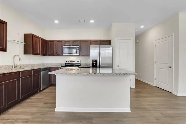 a kitchen with stainless steel appliances granite countertop a sink a stove a refrigerator and a oven