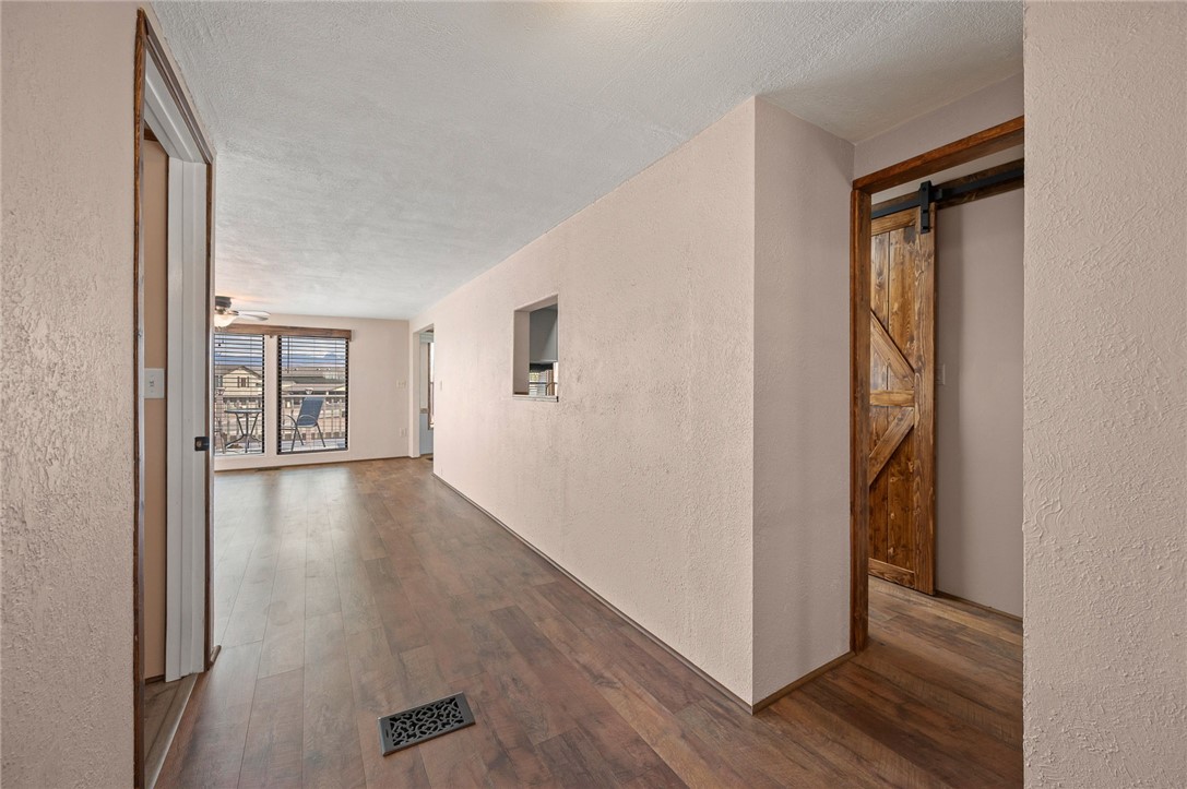 2000 Ramar Road, Unit 587 Bullhead City, AZ 86442 - Photo 12 of 79 Corridor featuring a textured wall, dark wood finished floors, a barn door, and a textured ceiling