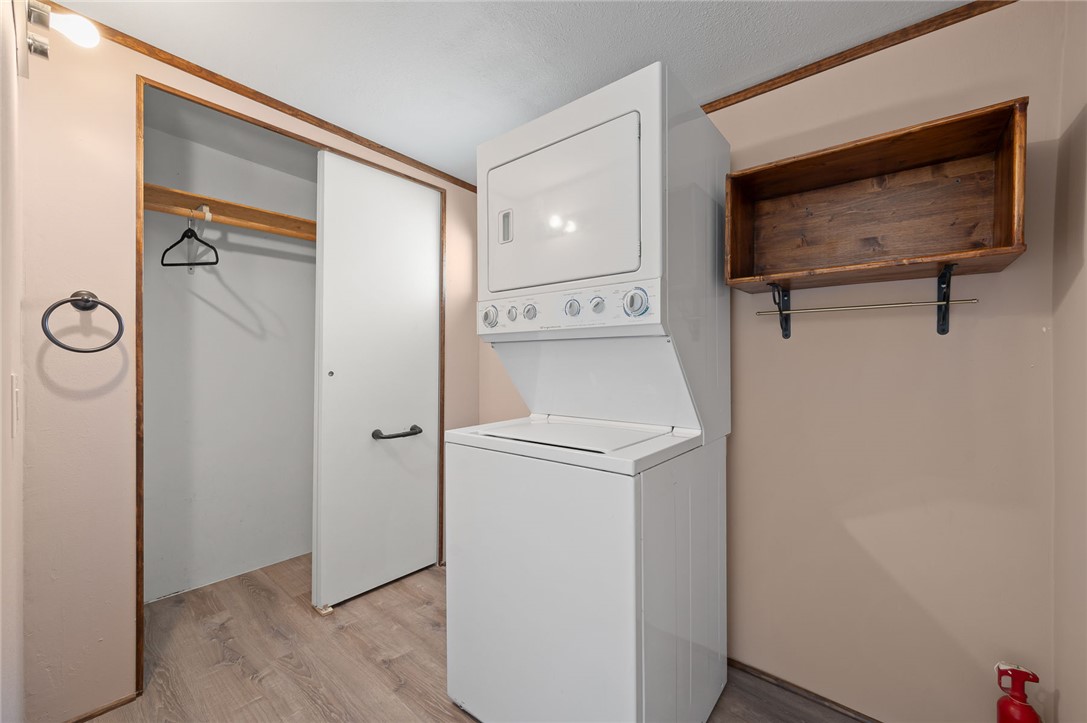 2000 Ramar Road, Unit 587 Bullhead City, AZ 86442 - Photo 13 of 79 Laundry area featuring light wood-type flooring and stacked washer / dryer, and location where seller is adding 2nd 1/2 bath