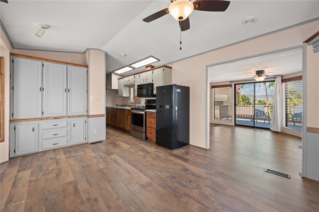 2000 Ramar Road, Unit 587 Bullhead City, AZ 86442 - Photo 20 of 79 Updated Kitchen featuring black appliances, dark wood finished floors, ceiling fan, vaulted ceiling, and light countertops