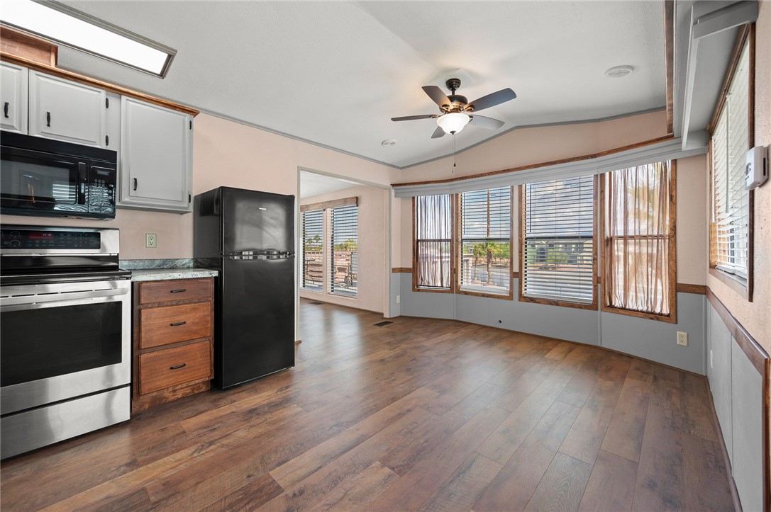 2000 Ramar Road, Unit 587 Bullhead City, AZ 86442 - Photo 23 of 79 Kitchen featuring black appliances, vaulted ceiling, dark wood finished floors, ceiling fan, and white cabinetry