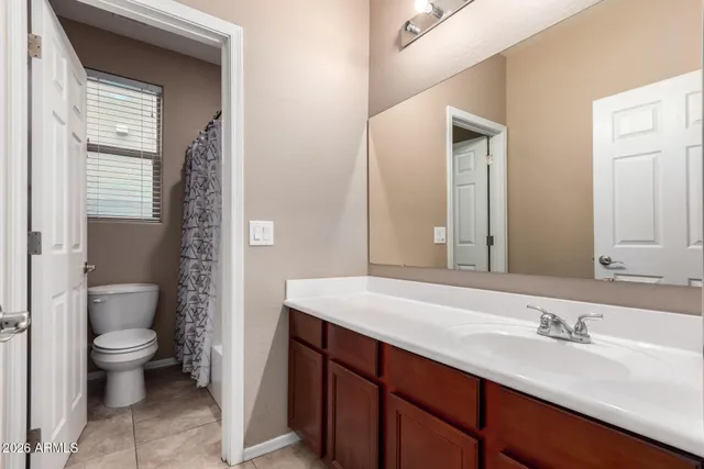 a bathroom with a granite countertop sink a toilet and a mirror