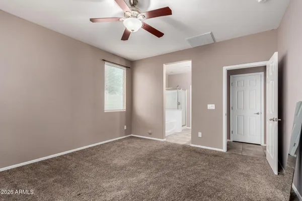 an empty room with closet and a chandelier fan