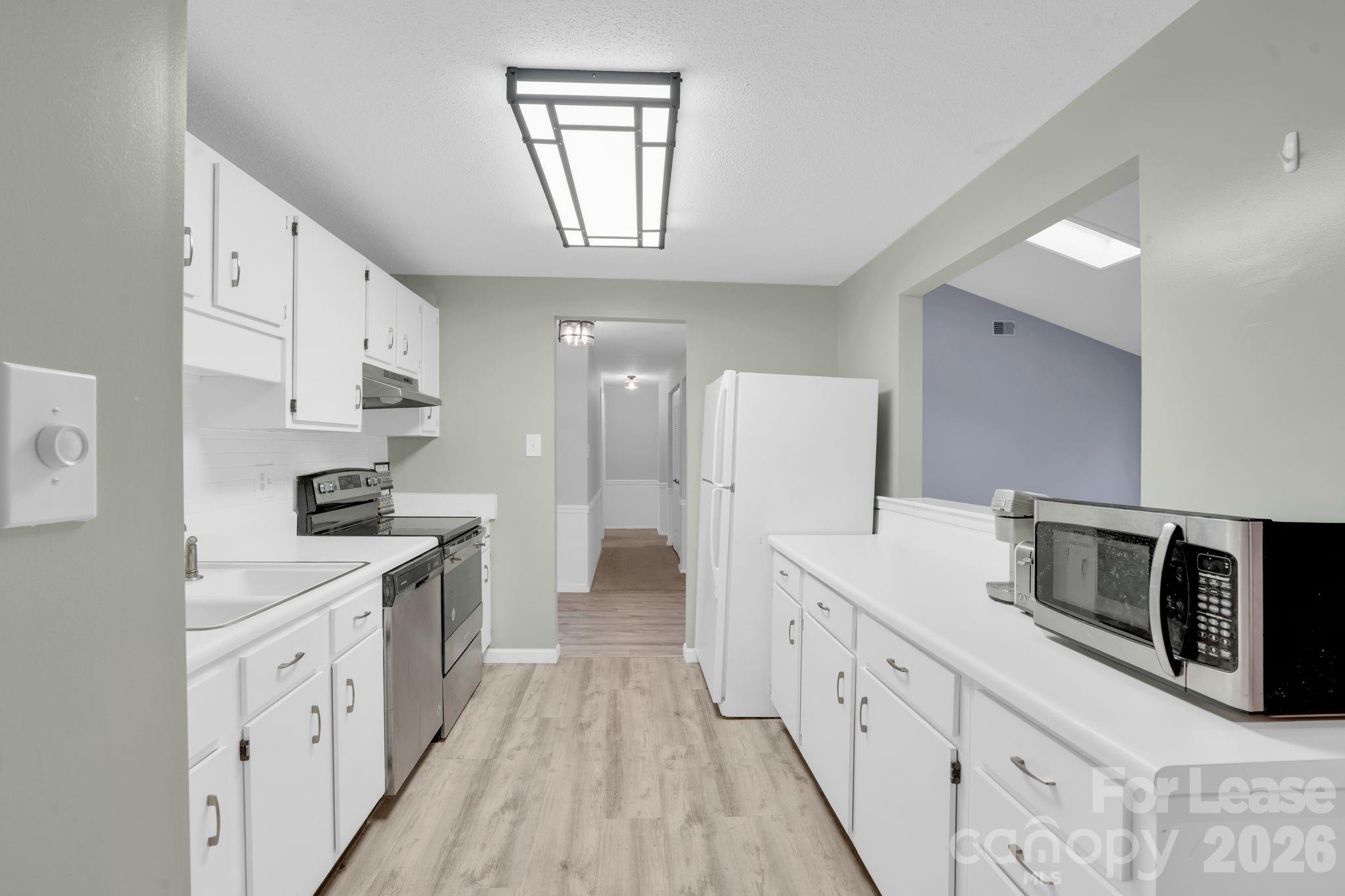 2427 Studley Road Charlotte, NC 28212 - Photo 16 of 30 a kitchen with white cabinets and stainless steel appliances