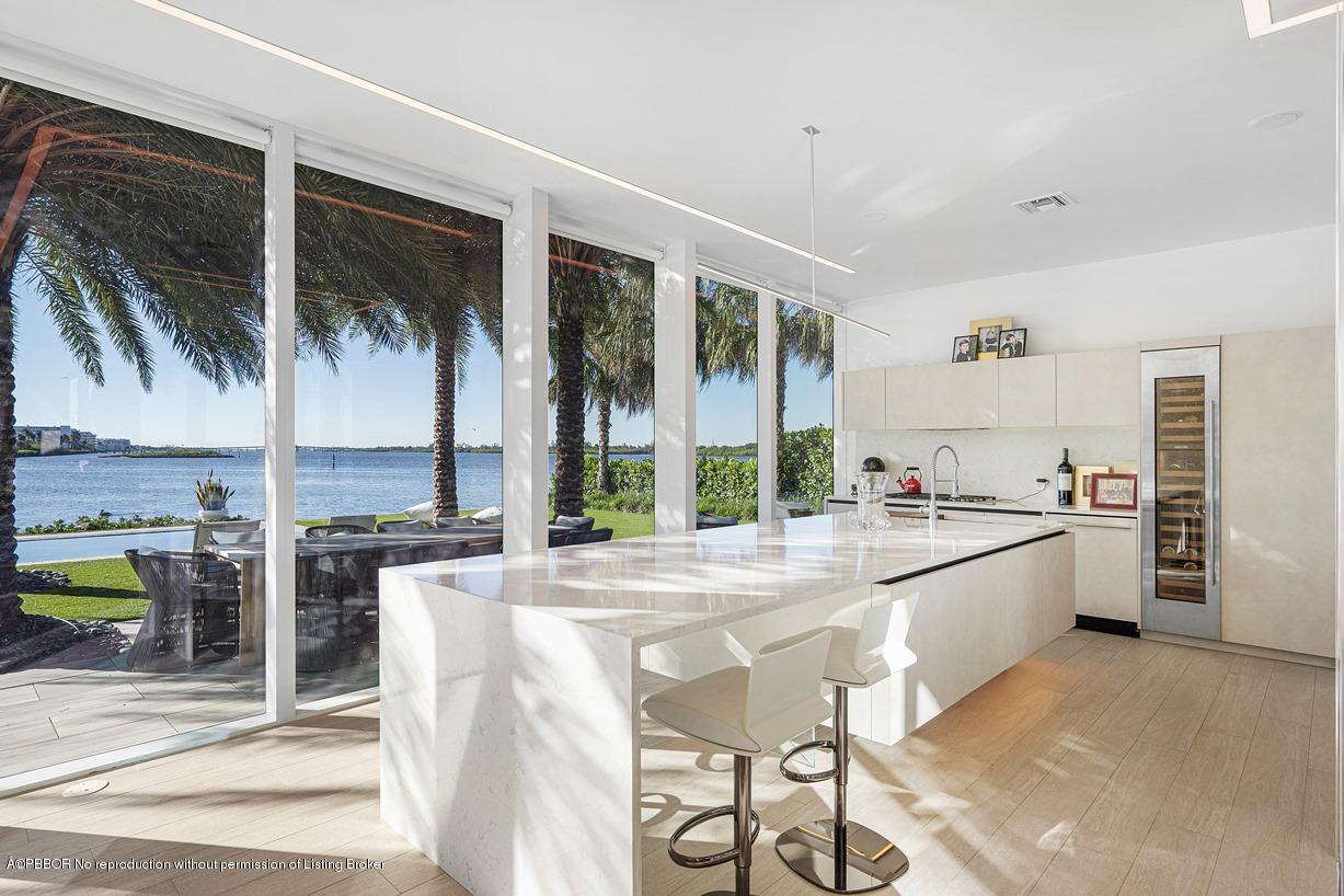 2299 Ibis Isle Road East Palm Beach, FL 33480 - Photo 17 of 37 a large white kitchen with a large window and stainless steel appliances