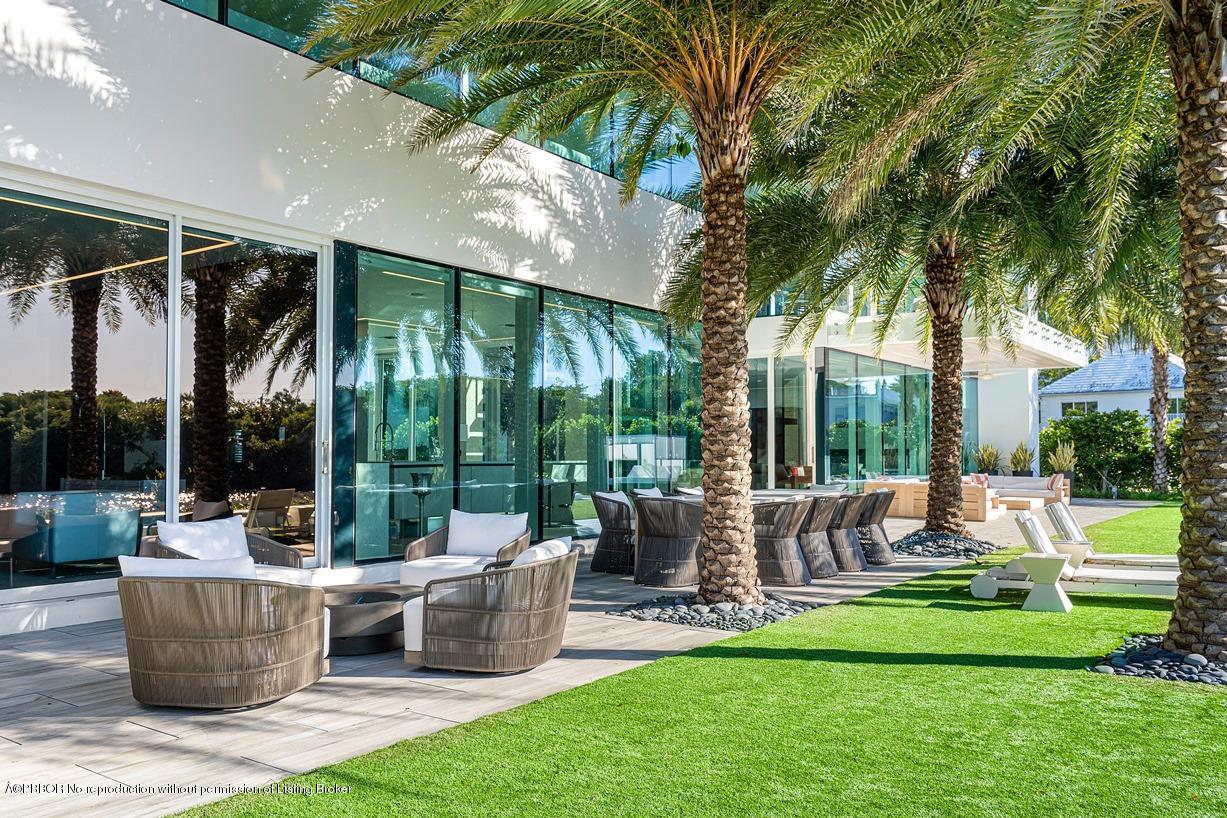 2299 Ibis Isle Road East Palm Beach, FL 33480 - Photo 25 of 37 a view of a patio with table and chairs potted plants and palm tree