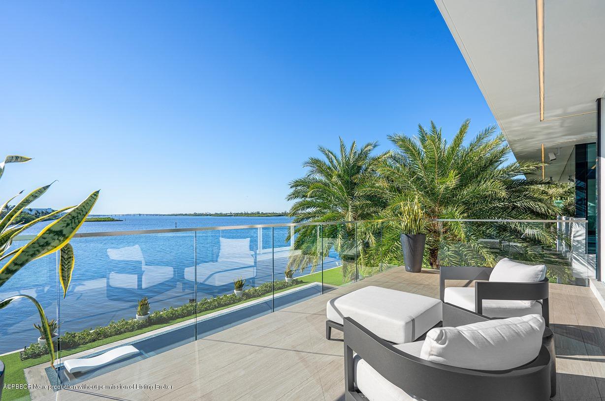 2299 Ibis Isle Road East Palm Beach, FL 33480 - Photo 26 of 37 a view of a patio with couches and a table and chairs with wooden floor