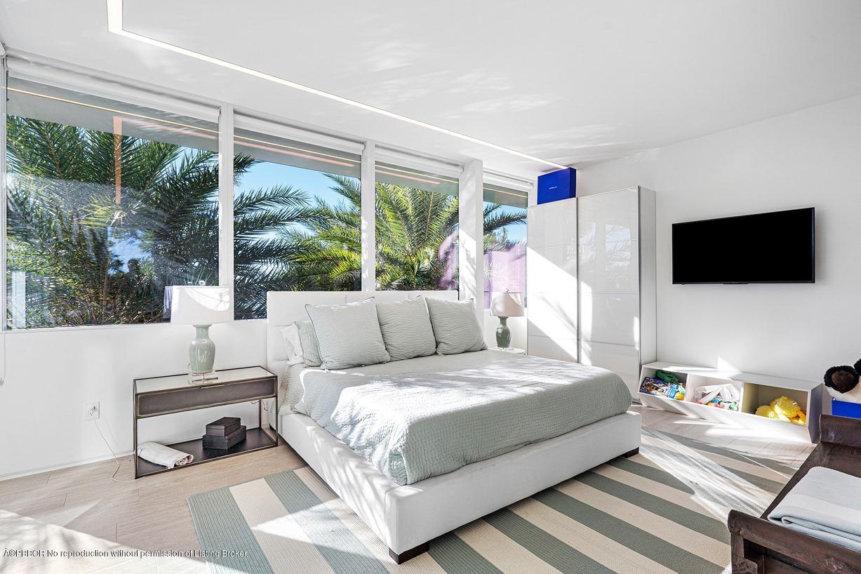 2299 Ibis Isle Road East Palm Beach, FL 33480 - Photo 32 of 37 a bedroom with a bed and a flat screen tv
