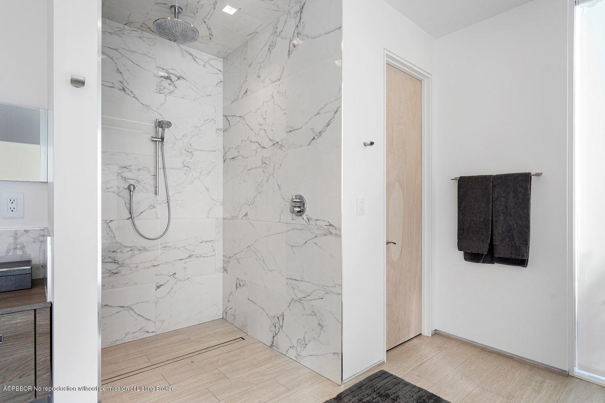 2299 Ibis Isle Road East Palm Beach, FL 33480 - Photo 34 of 37 a bathroom with a glass shower door