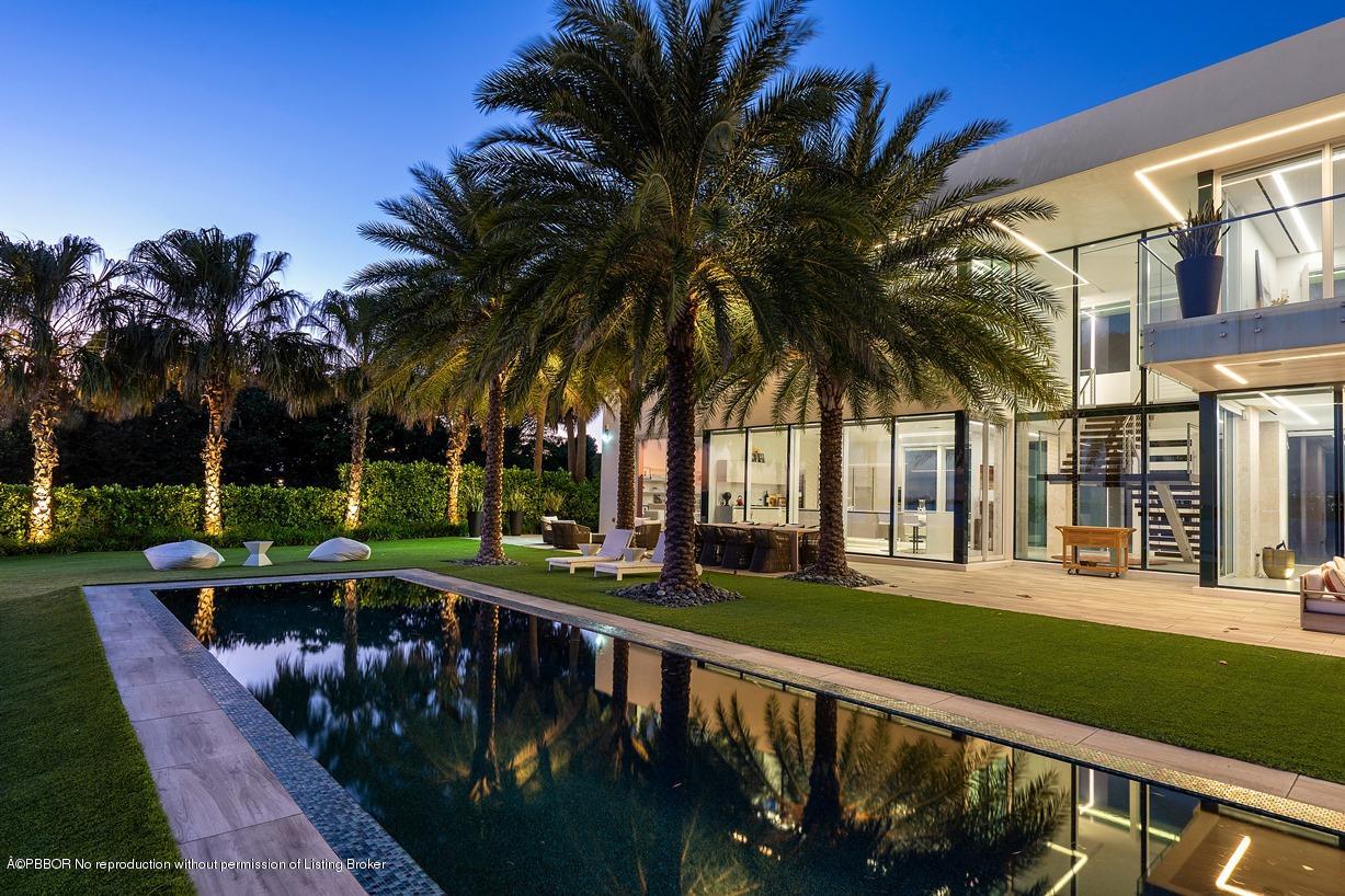 2299 Ibis Isle Road East Palm Beach, FL 33480 - Photo 10 of 37 a view of a house with a swimming pool and a porch
