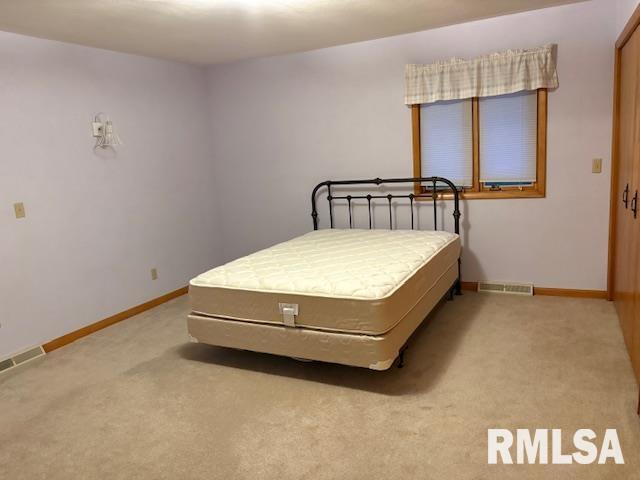 15614 63rd Street Milan, IL 61264 - Photo 18 of 25 a bed sitting in a room next to a window