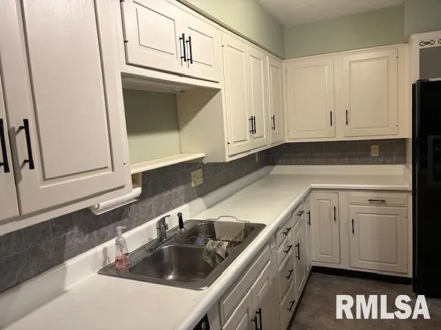 a kitchen with granite countertop white cabinets and sink