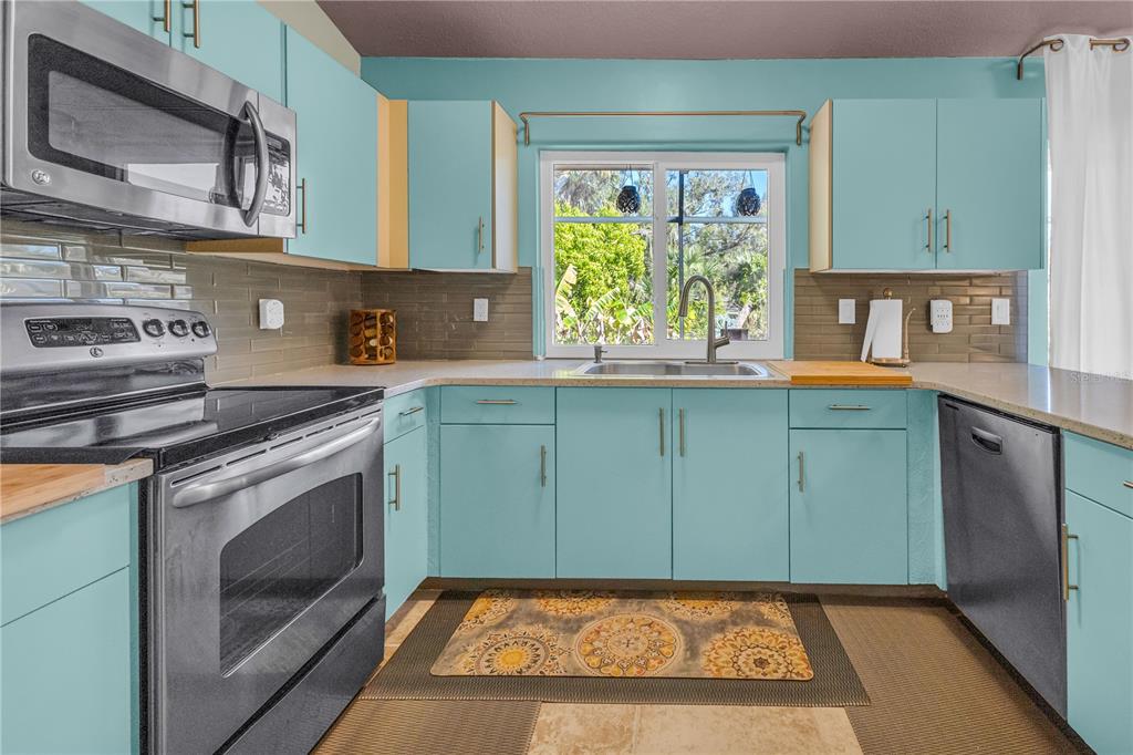 1035 Sirus Trail Sarasota, FL 34232 - Photo 12 of 48 a kitchen with stainless steel appliances granite countertop a stove a sink and a microwave