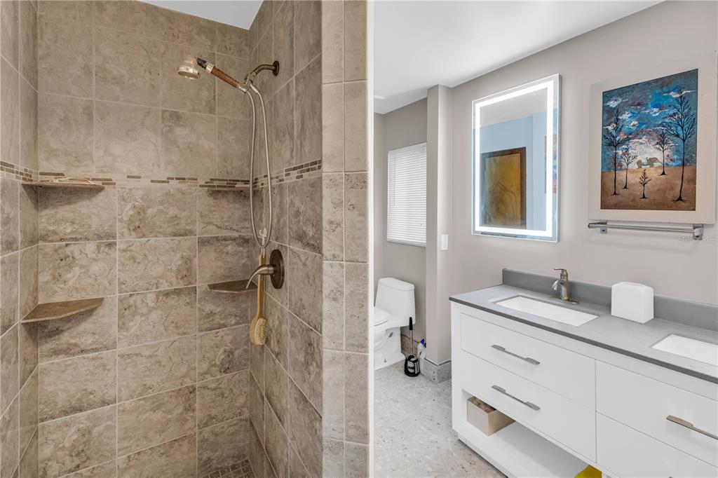 1035 Sirus Trail Sarasota, FL 34232 - Photo 34 of 48 a bathroom with a granite countertop sink a mirror a shower and a bathtub