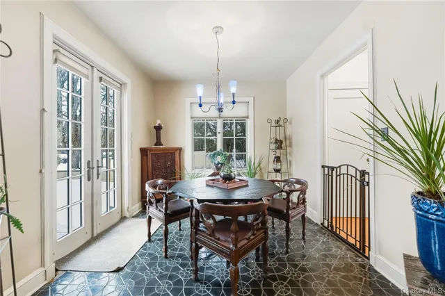 a dining room with furniture a chandelier and wooden floor