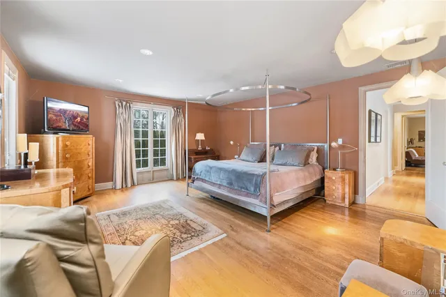 a spacious bedroom with a bed a mirror and lamp