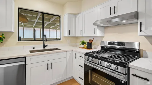 a kitchen with cabinets appliances and a window