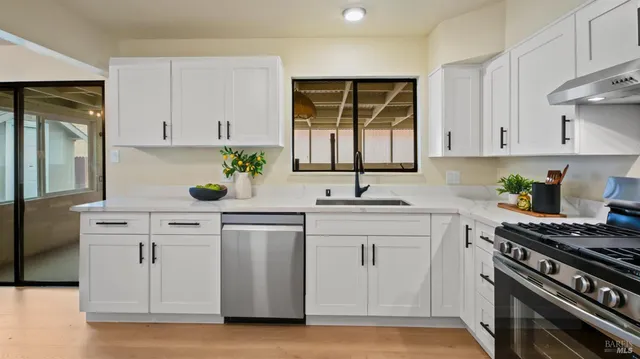 a kitchen with white cabinets and appliances