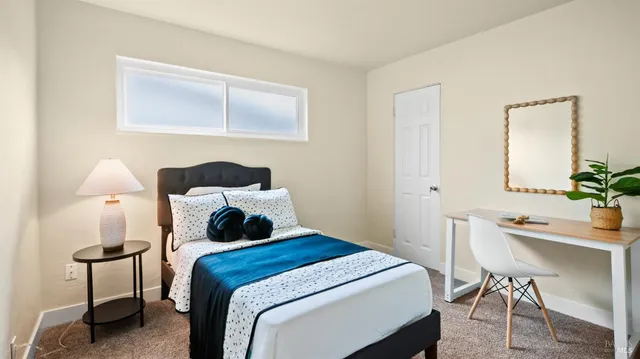 a bedroom with a bed a table and chair