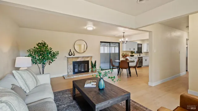 a living room with furniture a fireplace and a potted plant