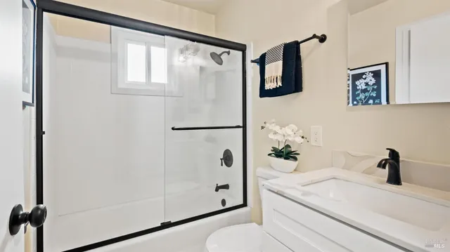 a bathroom with a bathtub shower sink and mirror