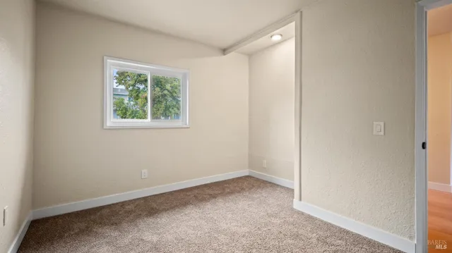 an empty room with windows and closet