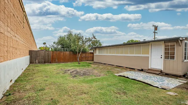 a view of backyard with wooden fence
