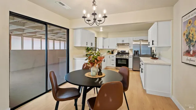 a view of a dining room with furniture a chandelier and wooden floor