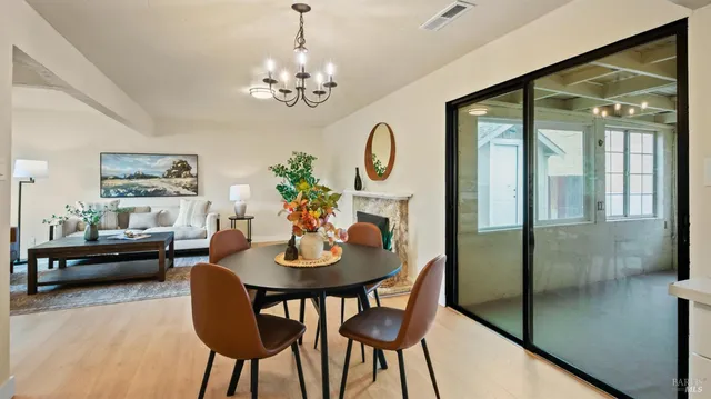 a view of a dining room with furniture a chandelier and wooden floor