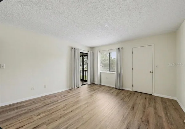 a view of an empty room with wooden floor