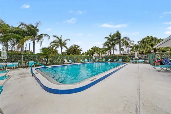 a view of a swimming pool with a yard and sitting area