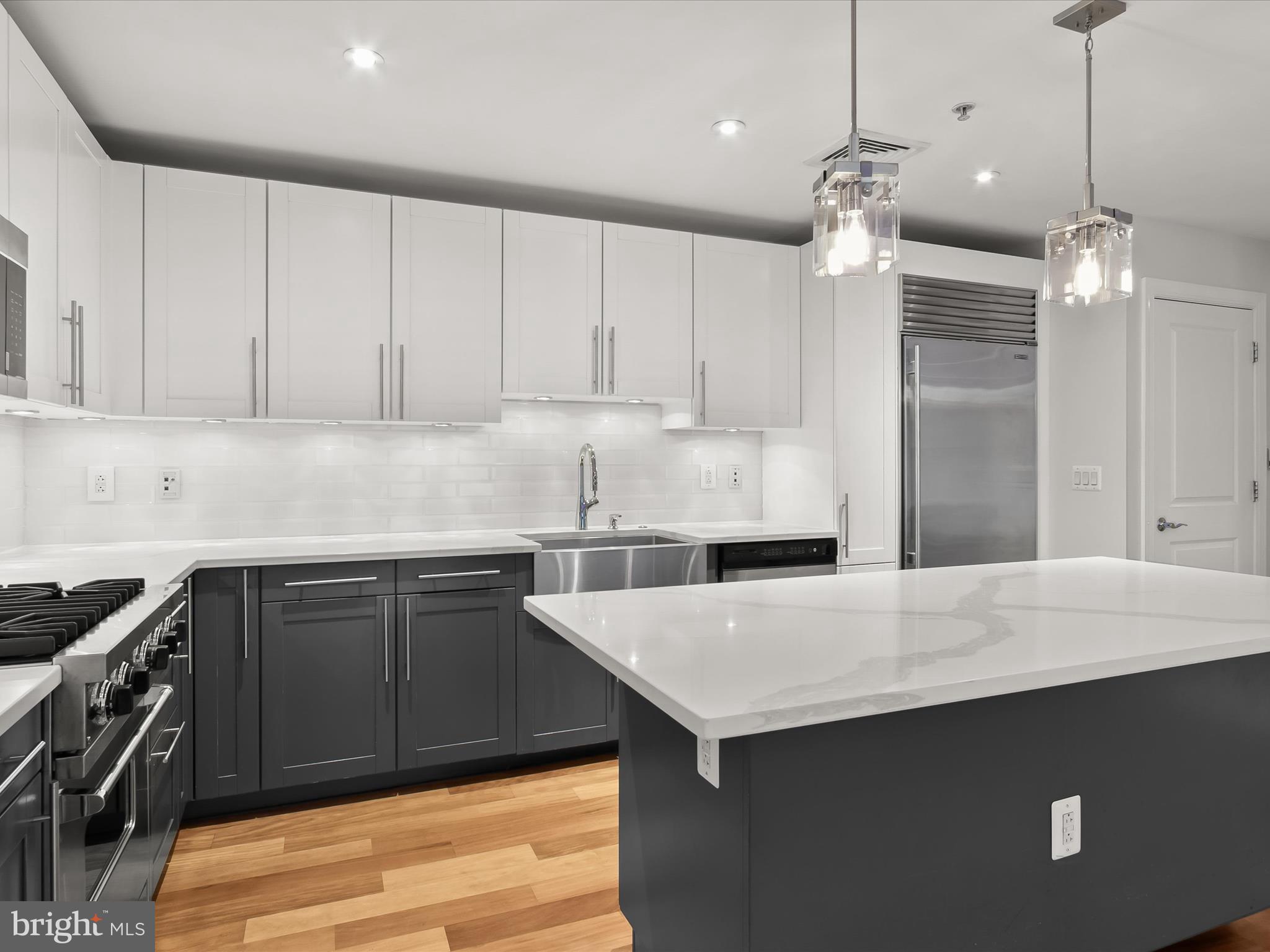 2425 L Street Northwest, Unit 239 Washington, DC 20037 - Photo 11 of 43 a kitchen with a sink dishwasher a stove and a refrigerator with wooden floor
