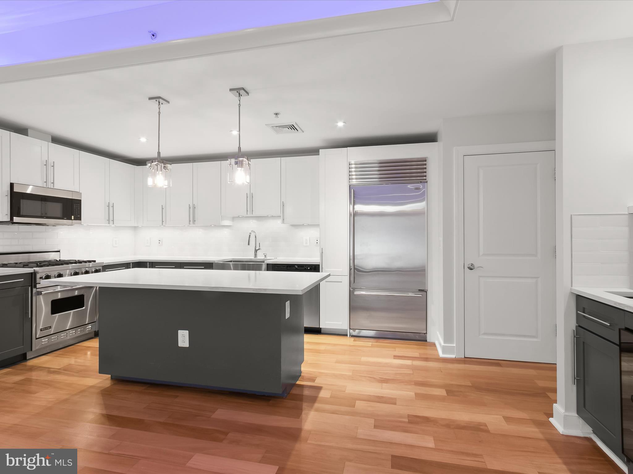 2425 L Street Northwest, Unit 239 Washington, DC 20037 - Photo 9 of 43 a kitchen with kitchen island a counter top space a sink and appliances