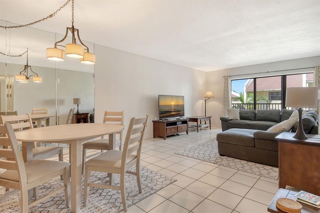 6157 Midnight Pass Road, Unit E63 Sarasota, FL 34242 - Photo 8 of 61 a living room with furniture a flat screen tv and a large window