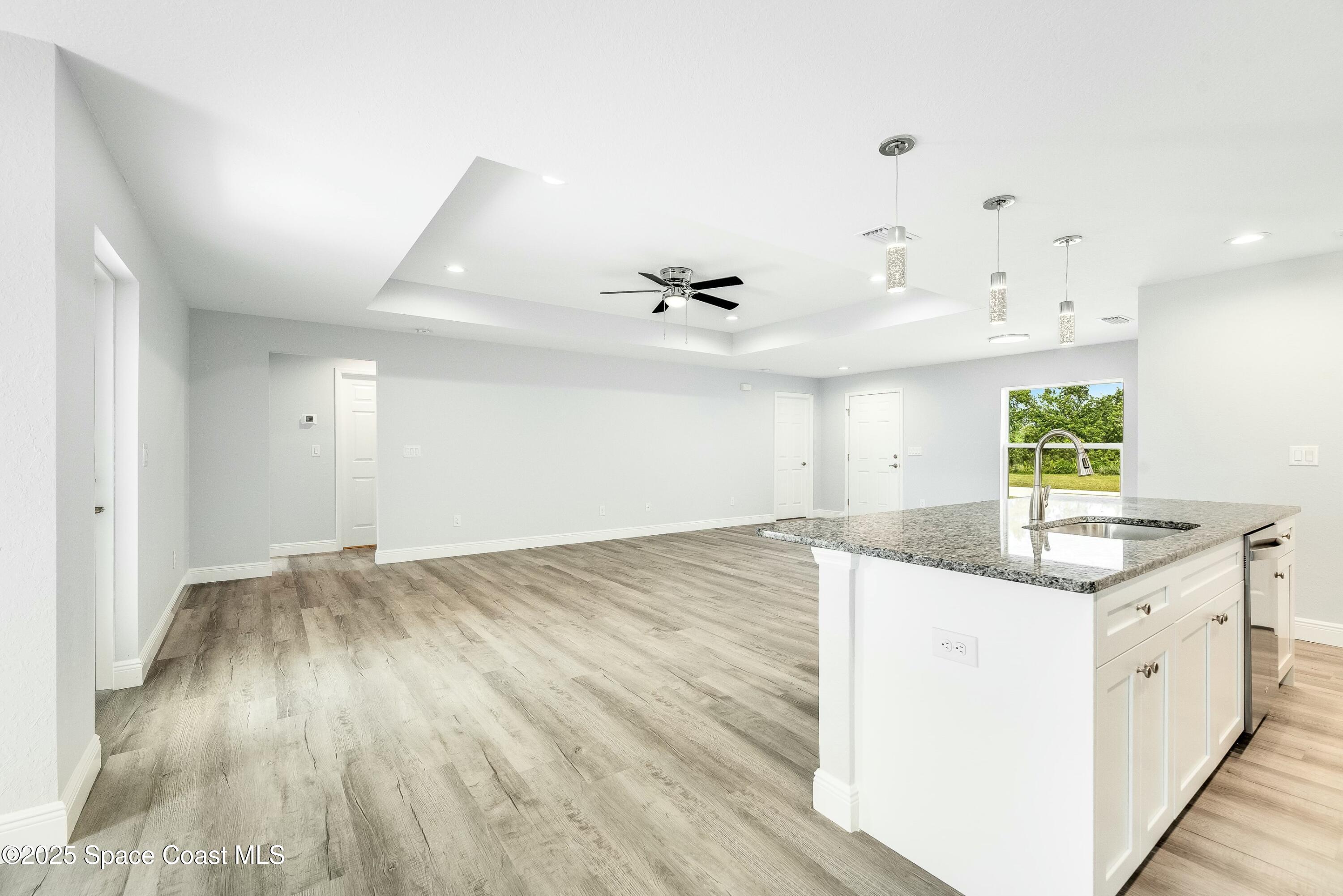 1341 Defender Street Northwest Palm Bay, FL 32907 - Photo 13 of 38 an empty room with wooden floor and windows