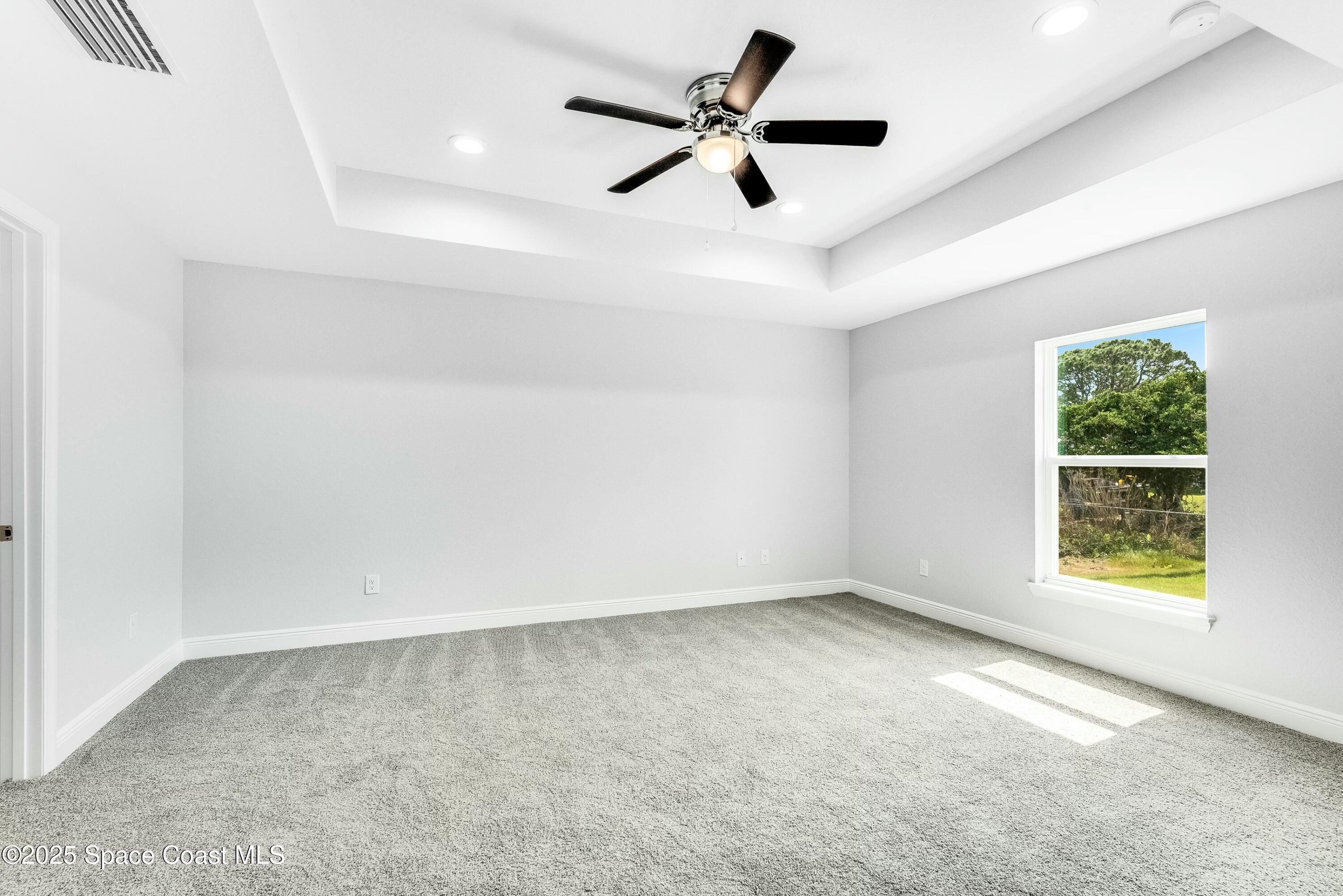 1341 Defender Street Northwest Palm Bay, FL 32907 - Photo 21 of 38 an empty room with ceiling fan and windows