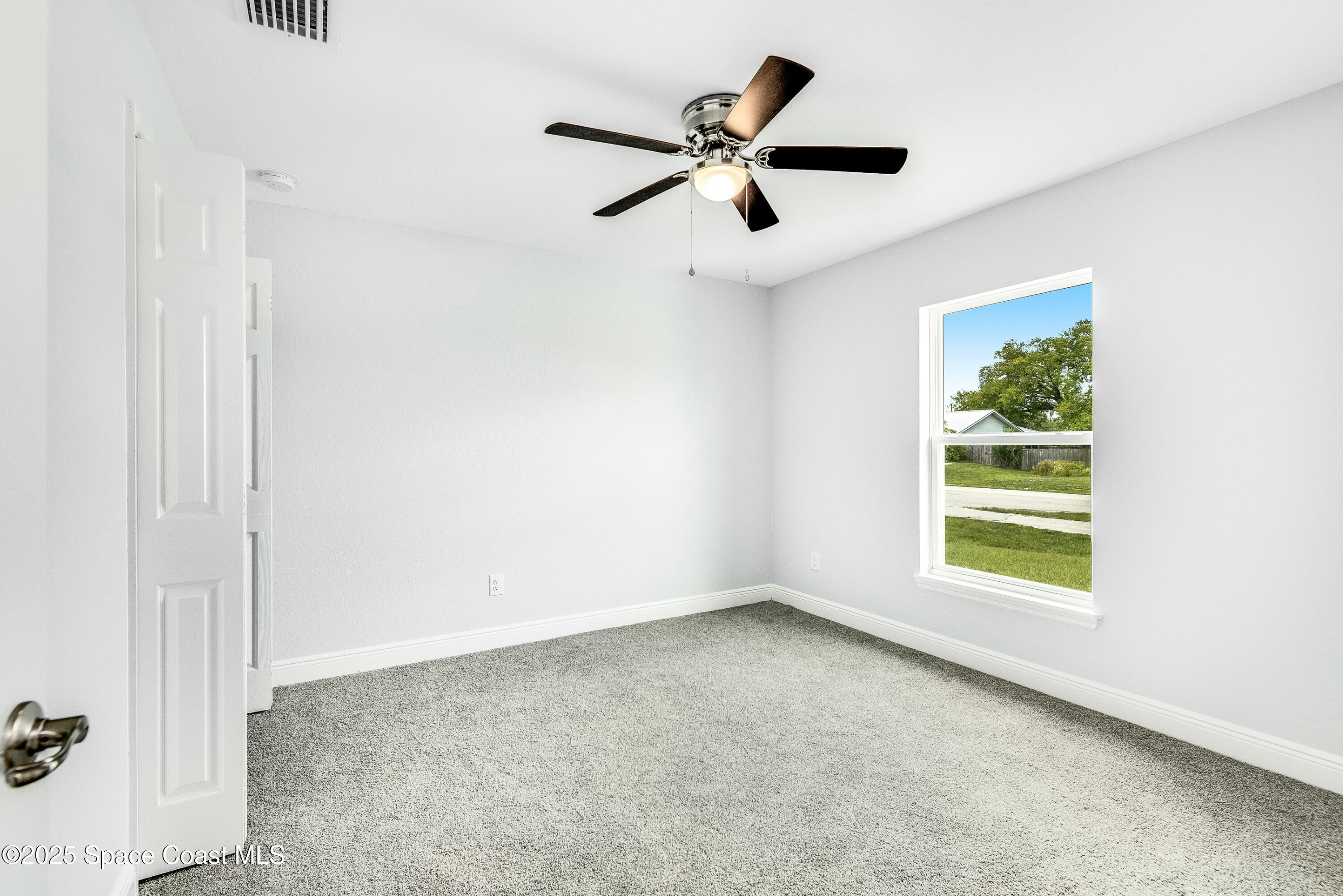 1341 Defender Street Northwest Palm Bay, FL 32907 - Photo 29 of 38 an empty room with a window and a ceiling fan