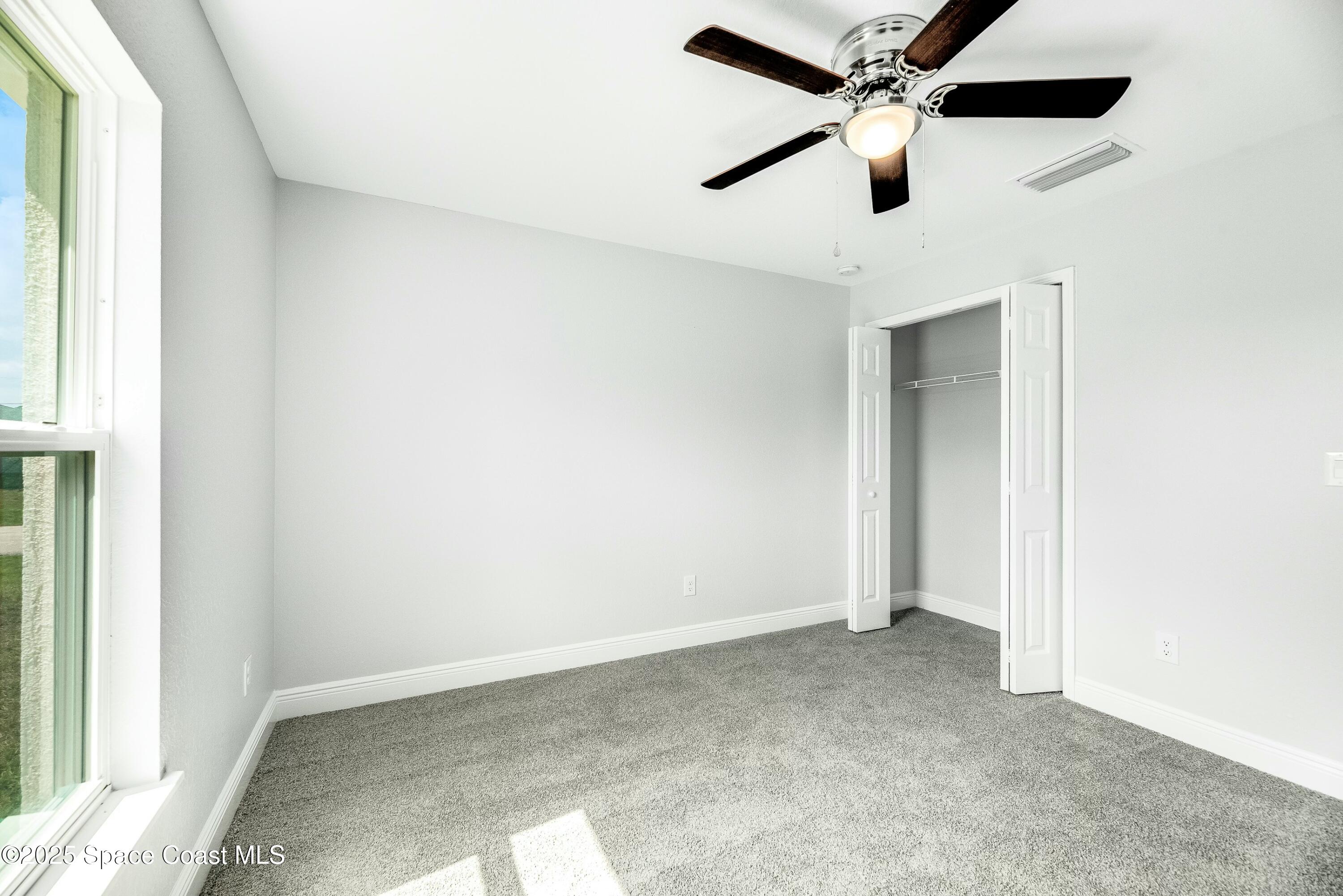 1341 Defender Street Northwest Palm Bay, FL 32907 - Photo 31 of 38 an empty room with a ceiling fan and window