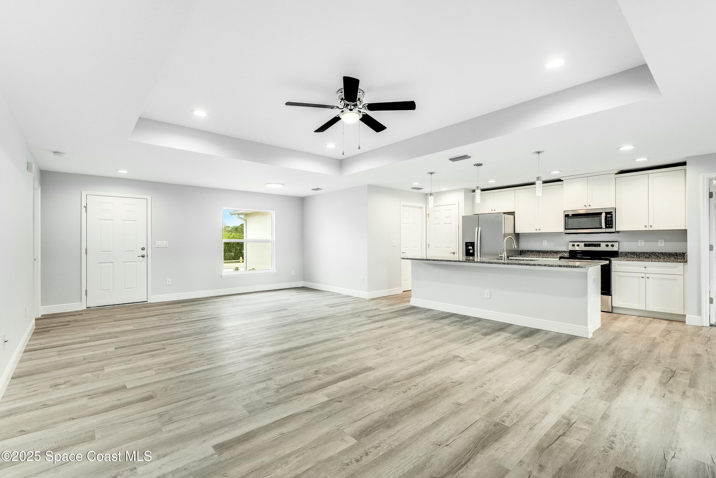 1341 Defender Street Northwest Palm Bay, FL 32907 - Photo 10 of 38 a view of kitchen with refrigerator microwave and stove