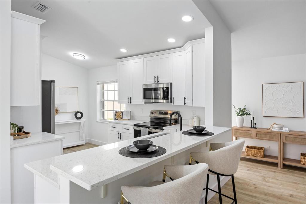 8330 Bermuda Sound Way Boynton Beach, FL 33436 - Photo 7 of 52 a kitchen with a sink a stove and chairs