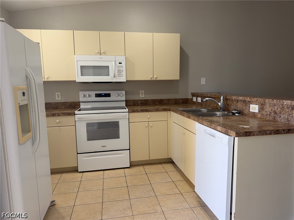4535 26th Street Southwest Lehigh Acres, FL 33973 - Photo 2 of 14 a kitchen with a stove a sink and a refrigerator