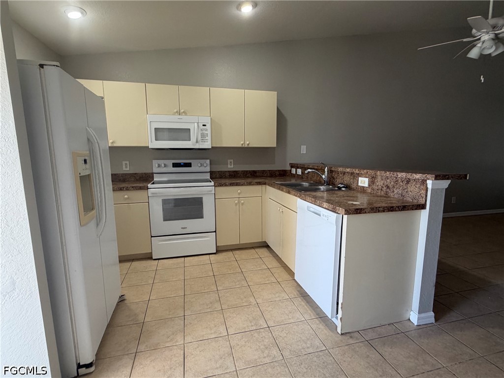 4535 26th Street Southwest Lehigh Acres, FL 33973 - Photo 3 of 14 a kitchen with a stove a sink and a refrigerator